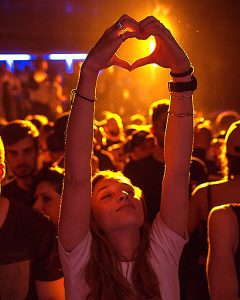 Woman Enjoying a Live Concert with Hands Raised